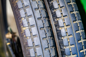 Close-up view of a motorcycle tire showcasing tread design and wheel structure in a workshop setting