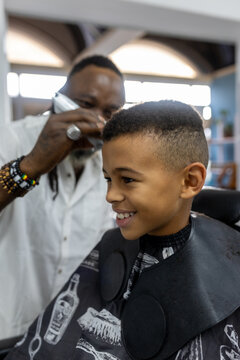 Mixed Race boy having his hair cut