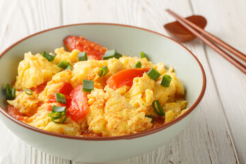 scrambled eggs with tomatoes, chinese food closeup on the plate on the wooden table. Horizontal