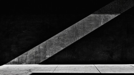 A black and white photograph of a concrete wall with a diagonal beam of light.