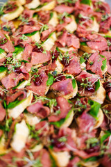 Savor flavorful pastrami canapés topped with fresh microgreens, berry glaze, and served on rustic toasted bread, perfect for festive gatherings and parties