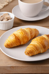 Delicious freshly baked croissants served with coffee and sugar cubes in a cozy setting