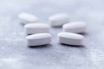Amino acids tablets on wooden background. Soft focus. Close up	