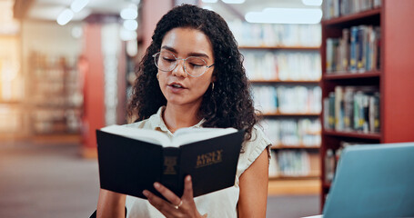 Woman, bible study and reading at library for learning for theology assessment at university. Girl, college student and research with religion, history and book for project, scholarship or education