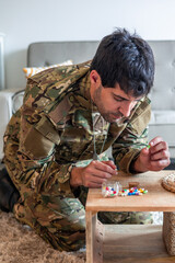vertical Depressed soldier taking pills at home suffering from post-traumatic stress disorder