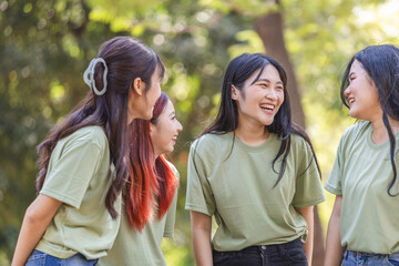 Fototapeta premium Cheerful young Asian female volunteer team in park for charity event