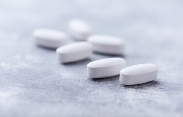 Amino acids tablets on wooden background. Soft focus. Close up	