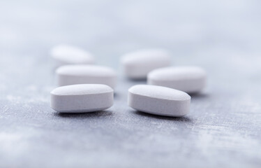 Amino acids tablets on wooden background. Soft focus. Close up	