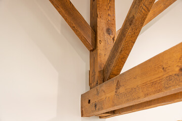 Charpentes en bois apparentes dans une pièce de vie chaleureuse, mêlant authenticité, volume et architecture intérieure de caractère. 