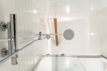 Vue en contre-plongée d’un pommeau de douche moderne avec des gouttes d’eau, illustrant un...
