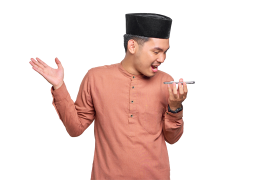 Cheerful young Asian Muslim man using the voice assistant on mobile phone isolated on transparent background