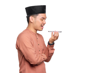 Smiling young Asian Muslim man using the voice assistant on mobile phone isolated on transparent background