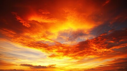 Obraz premium A dramatic sunset sky with vibrant orange, yellow, and red hues.
