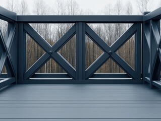 Dark gray composite deck with X-design railing overlooking a winter woodland