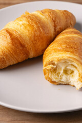 Freshly baked croissants on a plate showcasing flaky texture and golden color in a cozy kitchen setting