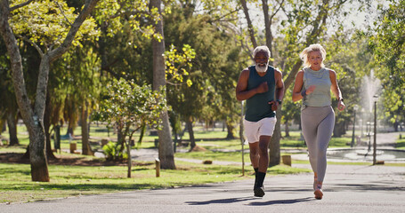 Obraz premium Fitness, elderly couple or running outdoor for training, cardio exercise or wellness in retirement. Interracial people, senior or workout at park for support, determination or morning routine in path