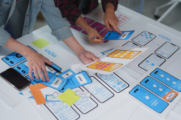 Web designers are building user interface for mobile application, collaborating on wireframes and...