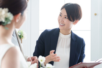 新郎新婦と話す結婚式場スタッフ