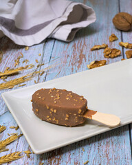 Chocolate and vanilla ice cream surrounded by chocolate toppings and nuts