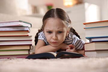 Upset girl with many different books on rug at home
