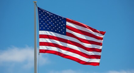 Fototapeta premium American Flag Waves Proudly Under a Clear Blue Sky