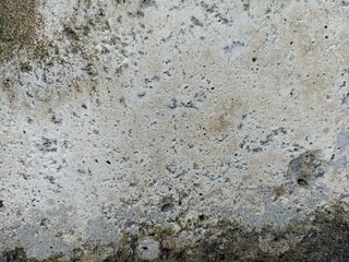 Aged Rough Concrete Wall with Natural Weathering. Close-up of an old rough concrete wall with holes, cracks, and stains. Perfect for backgrounds, textures, and industrial-themed designs