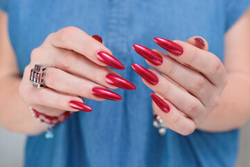 Female hands with long nails and red nail polish
