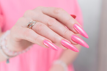 Fototapeta premium beautiful female hands with long nails and bright neon pink red nail polish