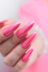 beautiful female hands with long nails and bright neon pink red nail polish