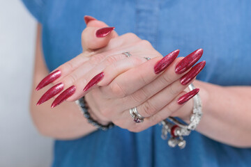 Female hand with long nails and a bright red manicure