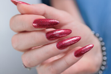 Female hand with long nails and a bright red manicure