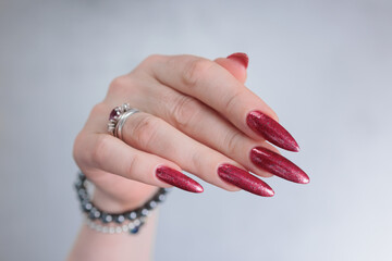 Female hand with long nails and a bright red manicure