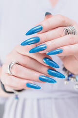 Woman's beautiful hand with long nails and bright blue manicure