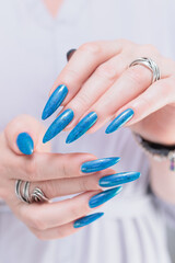 Woman's beautiful hand with long nails and bright blue manicure