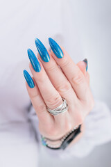 Woman's beautiful hand with long nails and bright blue manicure