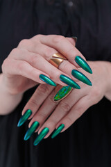 Fototapeta premium Woman's hand with long nails and green blue nail polish