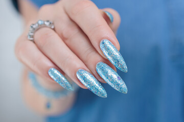Woman's beautiful hand with long nails and light baby blue manicure