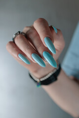 Woman's beautiful hand with long nails and light baby blue manicure