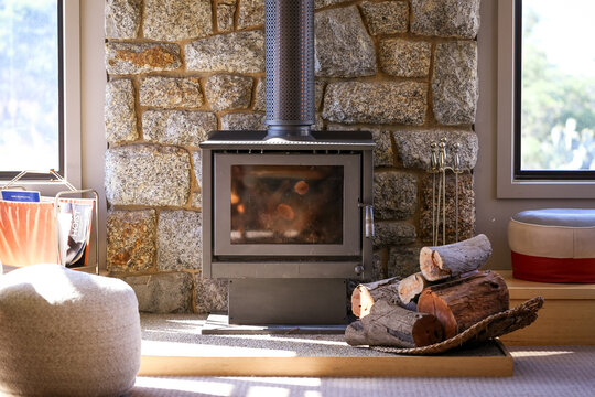 Logs stacked beside log fire in living room