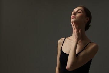 Woman with perfect skin on grey background. Space for text