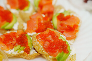 Sandwiches with avocado, red fish and caviar.