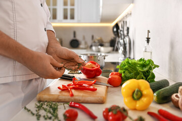 Professional chef with fresh products at counter in kitchen, closeup