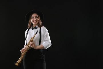Naklejka premium Musician with soprano saxophone on dark background. Space for text