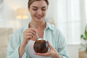 Woman with traditional yerba mate tea at home, selective focus
