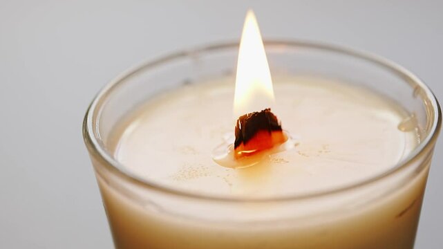 close-up. burning White soy candle with wooden wick in glass glass. making scented candles. 