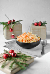 Fermented cabbage in a deep black dish . There are Christmas gift boxes nearby.