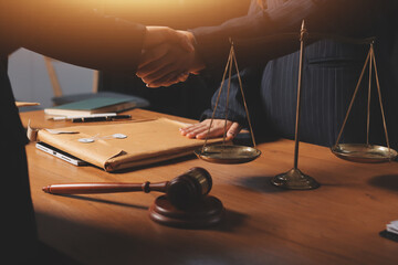 Attractive young lawyer in office Business woman and lawyers discussing contract papers with brass scale on wooden desk in office. Law, legal services, advice, Justice and real estate concept.