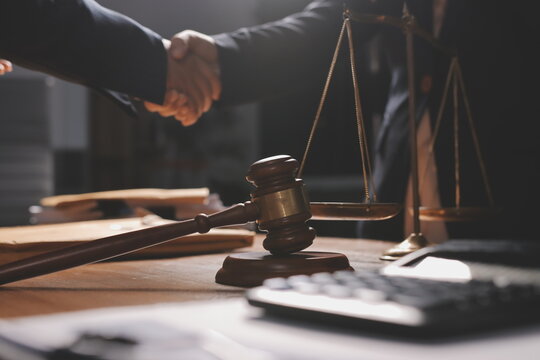 Attractive young lawyer in office Business woman and lawyers discussing contract papers with brass scale on wooden desk in office. Law, legal services, advice, Justice and real estate concept.