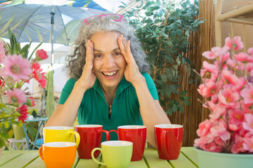 Mature woman with colorful mugs