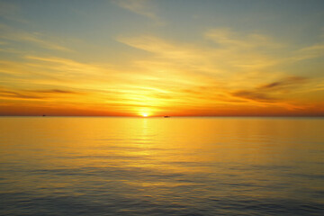 Fototapeta premium sunset over the ocean with the sun setting in the distance 2